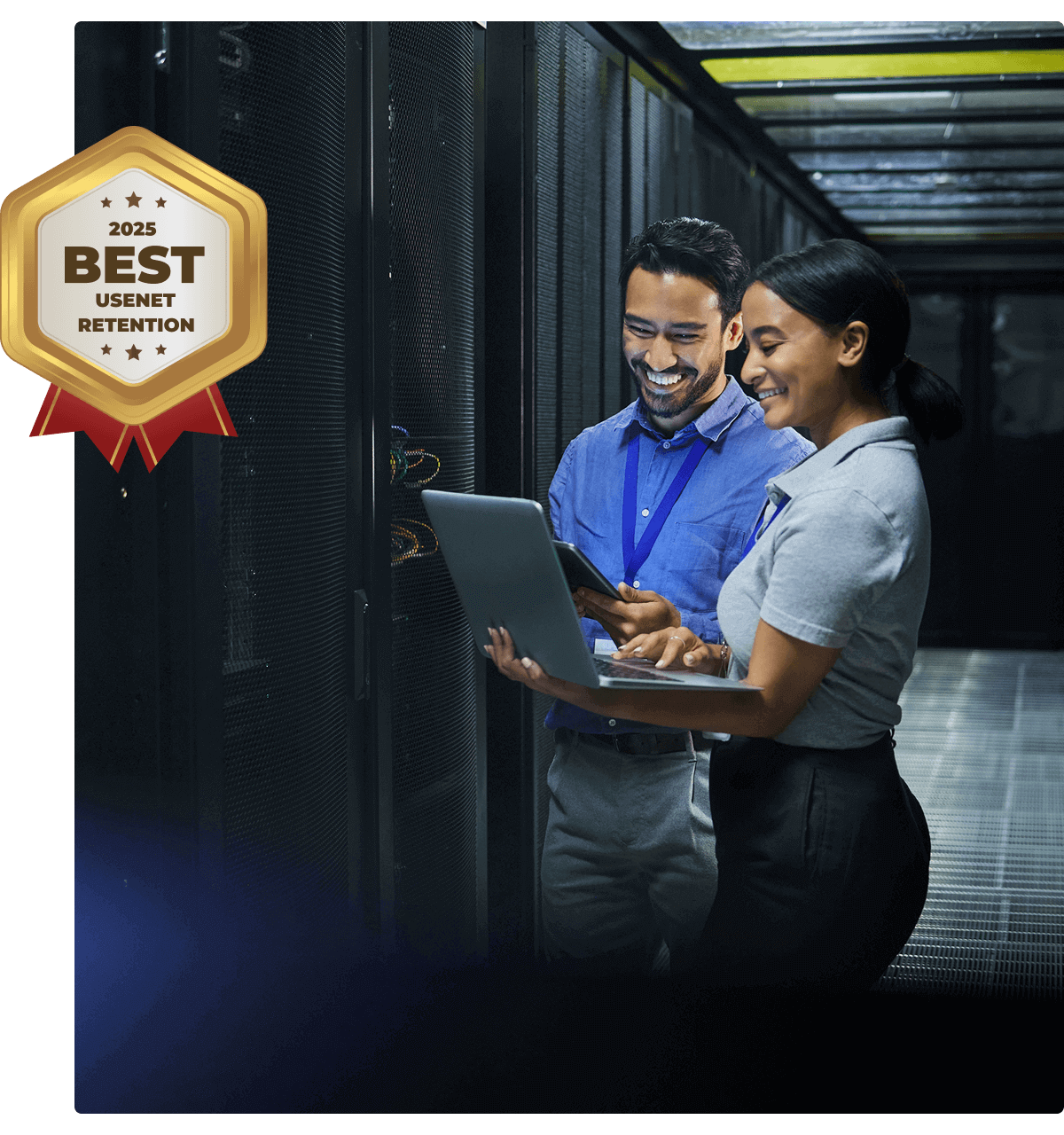 Two people working in a Usenet server room on a laptop, symbolizing that UsenetServer offers the best Usenet article retention.