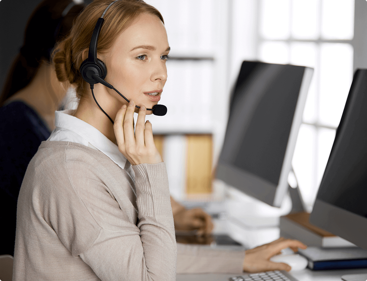 A woman wearing a headset is helping a customer over the phone, symbolizing UsenetServer’s 24/7 customer service.