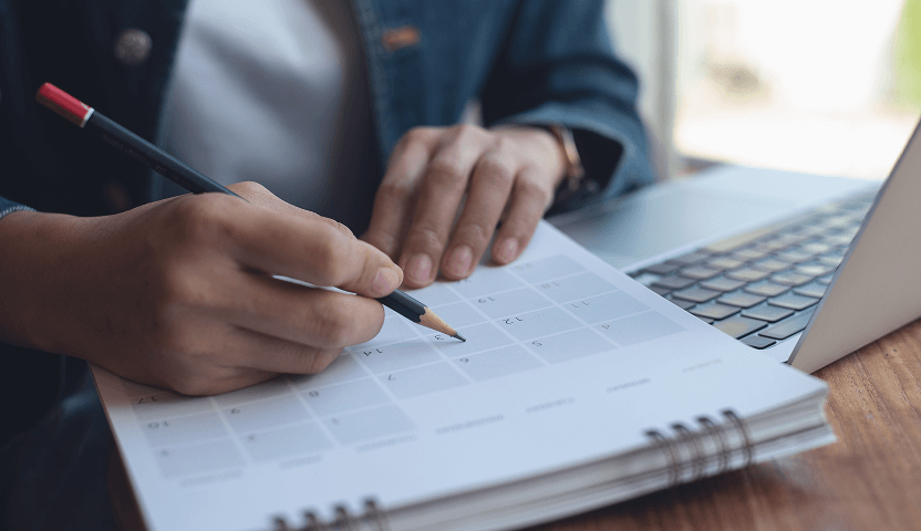 A person checking off dates on a calendar next to a laptop shows that UsenetServer stores more articles and discussions than any other Usenet provider.