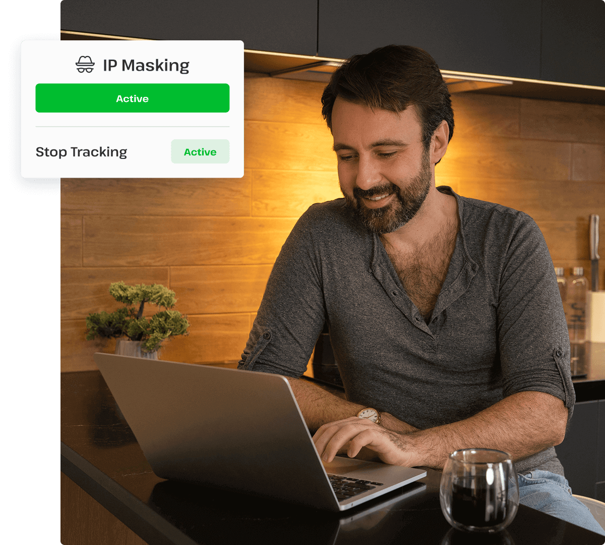A man with a beard is smiling and masking his IP address on his laptop.