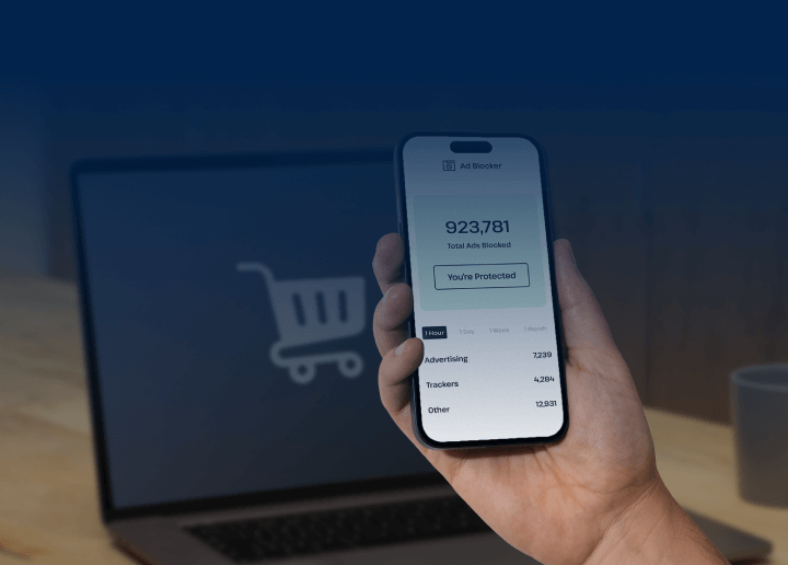 A smartphone is held up in front of a laptop, and the screen of the mobile device shows UsenetServer’s premium VPN and its ad blocker tool keeping the user safe from pop-ups.